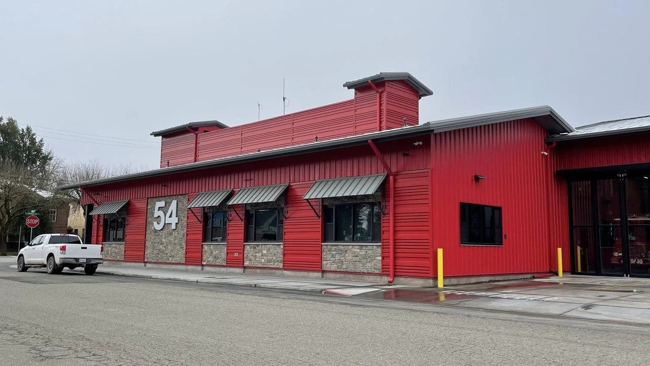 A red fire station building with the number 54; no people present