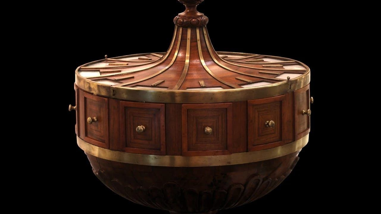 An ornate wooden ballot urn with brass fittings isolated on a black background; no people